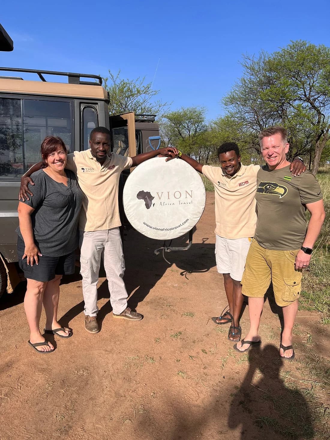 Two Vion Africa Travel guides with guests beside a Vion safari vehicle